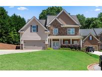 Charming two-story home with a stone and siding exterior and well-manicured lawn at 3415 Kenyon Creek Nw Dr, Kennesaw, GA 30152