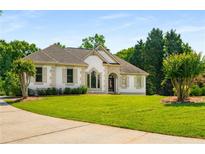 Charming single-story home with well-manicured lawn and elegant architectural details at 7025 Bavarian Wood Pl, Buford, GA 30518