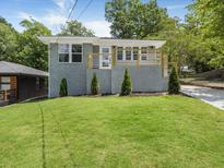 Charming gray brick home featuring a well-manicured front yard and a stylish front porch with modern railings at 1603 Ezra Church Nw Dr, Atlanta, GA 30314