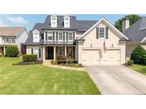 Charming two-story home with a well-manicured lawn and a classic colonial design at 5440 Old Haven Ct, Cumming, GA 30041