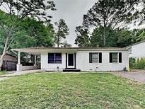 Charming single-story home with white brick exterior, green lawn, and a covered porch entrance at 908 Kennesaw Dr, Forest Park, GA 30297