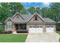 Charming stone and siding home with well-manicured lawn and a three-car garage at 295 Hanover Dr, Villa Rica, GA 30180