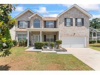 Two-story brick home featuring a well-manicured front yard and covered front porch at 507 Vaughan Dr, Hampton, GA 30228