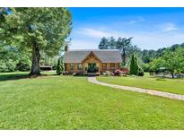 Inviting home featuring a lush front lawn and a charming stone pathway leading to the covered front porch at 179 Hogan Rd, Brooks, GA 30205