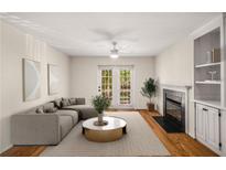 Bright living room with fireplace, built-in shelving, hardwood floors, and French doors offering abundant natural light at 3655 Habersham Ne Rd # 203, Atlanta, GA 30305