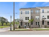 Modern townhome exterior with brick and white siding, large windows, and well-maintained landscaping at 2535 Astaire Ct, Atlanta, GA 30318
