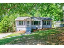 Charming single story home with a well maintained lawn, a few steps and trees in front at 1716 Beacon Hill Ne Blvd, Atlanta, GA 30329