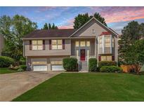 Charming two-story home with a well-manicured lawn, attached garage, and a welcoming front porch at 2577 Abbotts Glen Nw Dr, Acworth, GA 30101