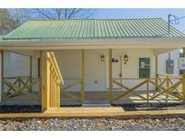 Charming home featuring a covered front porch, wooden railings and a metal roof at 3107 Hendrix Circle Sw, Covington, GA 30014