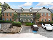 Two-story condo complex showing parking lot and exterior elevation with stairs to the units at 717 Beaufort Cir, Duluth, GA 30096