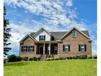 Charming brick two-story home featuring a well-manicured lawn and a welcoming front porch at 8967 Midlothian Ct, Winston, GA 30187