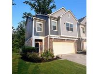 Charming two-story townhouse with a brick facade and attached two-car garage at 201 Jonquil Spring Rd, Woodstock, GA 30188