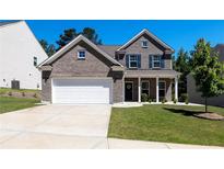 Charming two-story brick home with a well-manicured lawn and a two-car garage at 5440 Wheeler Ridge Rd, Auburn, GA 30011