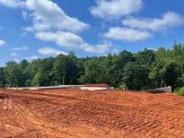 Land prepped for construction with foundation in place, surrounded by mature trees at 3065 Reserve Ct Sw, Conyers, GA 30094