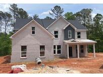 Charming two-story home with light brick, gray shingles, and covered front porch at 3292 Mill Forest Dr, Conyers, GA 30094