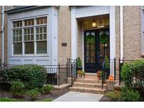 Charming brick home featuring a black front door, wreaths, and manicured landscaping at 661 Lockton Pl, Sandy Springs, GA 30342