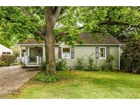 Charming home featuring green siding, a covered porch, and a lush, mature tree in the front yard at 1682 Grace Se St, Atlanta, GA 30316