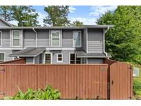 Charming townhome with a gray exterior, complemented by a privacy fence and lush greenery at 5040 Meadow Lane Ne, Marietta, GA 30068