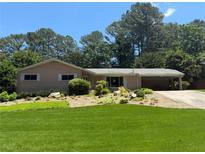 Charming ranch-style home featuring a well-manicured lawn and beautiful landscaping at 1533 High Haven Ne Ct, Atlanta, GA 30329