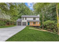 Charming two-story home featuring a welcoming porch, a two-car garage, and a well-manicured lawn at 2599 Willow Creek Dr, Duluth, GA 30096