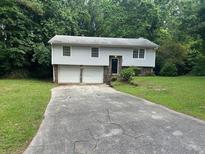 Charming two-story home featuring a two-car garage and well-maintained lawn at 6956 Kimberland Gardens Ln, Lithonia, GA 30058