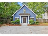 Charming blue house featuring a well-manicured lawn, inviting front porch, and mature landscaping at 2089 College Ne Ave, Atlanta, GA 30317