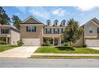 Charming two-story home featuring a brick facade, attached two-car garage, and well-manicured front lawn at 18 Dorothy Ln, Lawrenceville, GA 30046