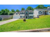Traditional two-story home with stone accents, a well-manicured lawn, and an attached two-car garage at 3283 Sugar Creek Falls Se Ave, Atlanta, GA 30316