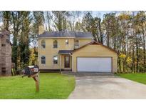 Charming yellow two-story home with a well-manicured lawn and attached garage, perfect for Gathering living at 3845 Springleaf Ct, Stone Mountain, GA 30083