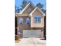 Charming two-story townhouse with brick and siding exterior and attached two-car garage at 1233 Miss Irene Ln, Lawrenceville, GA 30044