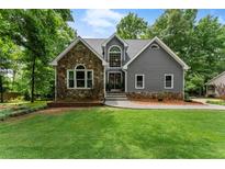 Charming home featuring stone accents, gray siding, and a beautifully landscaped front yard at 1920 Pilgrim Rd, Cumming, GA 30040