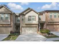 Beautiful townhome with attached garage, brick and siding facade, and manicured landscaping at 1360 Sugar Glen Ct, Lawrenceville, GA 30044