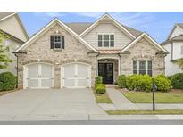 Charming brick home with a two-car garage, complemented by manicured landscaping at 11375 Crestview Ter, Johns Creek, GA 30024