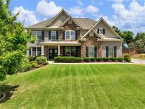 Beautiful brick and stone home with a well-manicured lawn and inviting curb appeal at 5220 Southern Hills Ln, Cumming, GA 30040