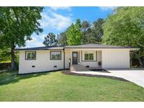 Charming home with white painted brick, dark trim, fresh landscaping, and a well-manicured lawn at 6090 Heritage Se Way, Mableton, GA 30126