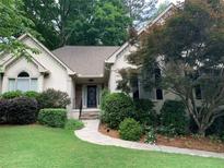 Charming single-story home featuring lush landscaping and a welcoming front entrance with a stone walkway at 1205 Rivershyre Ne Pkwy, Lawrenceville, GA 30043