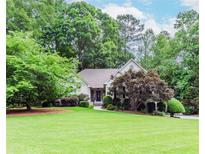 Beautiful single-story home with a well-manicured lawn and mature trees, offering great curb appeal at 1205 Rivershyre Ne Pkwy, Lawrenceville, GA 30043
