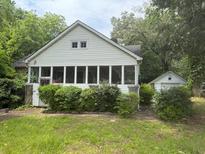 Charming bungalow-style home with a sunroom and detached garage at 602 Hamilton Holmes Dr, Atlanta, GA 30318