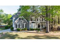 Charming gray two-story home with black shutters, lush landscaping, and a well-manicured front lawn at 251 Waterford Cove Dr, Suwanee, GA 30024