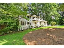 Charming two-story home with white siding, dark shutters, and a beautifully landscaped front yard at 2935 Leafwood Se Dr, Marietta, GA 30067