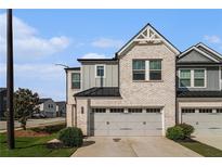 Charming two-story townhome with a brick and gray facade, two-car garage, and well-maintained landscaping at 4627 Piston Sw Jct, Mableton, GA 30126