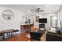 Open-concept living room features a modern ceiling fan and flows into the kitchen with bar seating at 1202 Key Se Rd, Atlanta, GA 30316