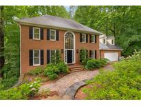 Charming brick home featuring a beautifully landscaped front yard and a classic, symmetrical design at 355 Highlands Trce, Roswell, GA 30075