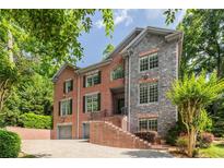 Stately brick home with stone accents, mature trees, and a two-car garage at 576 Cliftwood Ct, Sandy Springs, GA 30328