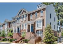 Charming townhome exterior with brick facade, covered entry, and well-maintained landscaping at 2325 Limehurst Ne Dr, Atlanta, GA 30319