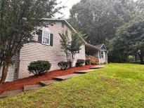 Charming home with landscaped yard and stone steps leading to the entrance at 80 Brooks Ln, Dallas, GA 30157