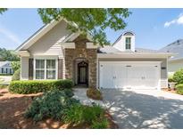 Charming home featuring a stone entryway, two-car garage, and well-maintained landscaping at 6350 Manningtree Ct, Cumming, GA 30041
