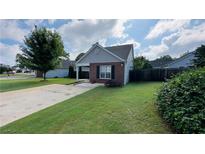 Charming single-story home featuring manicured lawn, gray siding and a brick accent wall at 1972 Brittania Cir, Woodstock, GA 30188