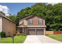 Charming two-story home featuring a brick facade, two-car garage, and a well-maintained front yard at 2521 Livingston Ct, Loganville, GA 30052
