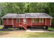 Charming ranch home featuring red wood siding, and a welcoming front porch and landscaped front yard at 4771 N Springs Nw Rd, Kennesaw, GA 30144